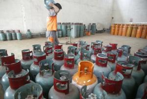 A worker carries a cylinder of Liquefied Petroleum Gas (LPG) in Foshan, Guangdong province, October 20, 2008. Photo courtesy of Reuters.