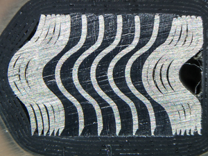 Fig. 5. Cross-section of a spiral-wound gasket showing alternating bands of stainless steel windings and graphite filler.